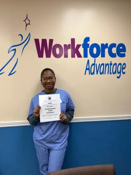 Carina Normil holding her CNA training certificate at Urban WorkForce Advantage