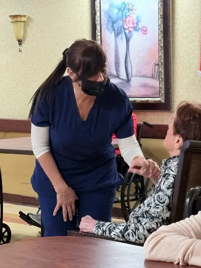Geraldine Arcia providing care to an older adult in a healthcare setting