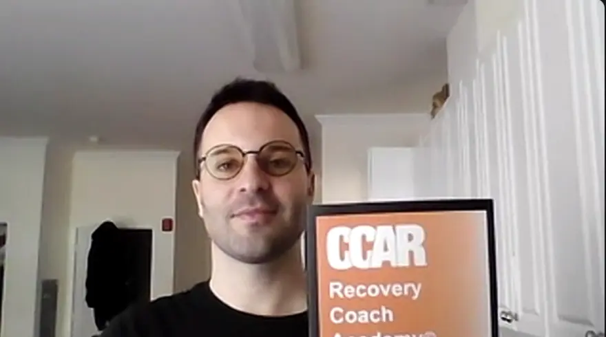 Phillip Mastrotto holding a CCAR Recovery Coach Academy guide during the January 2025 CPRS class
